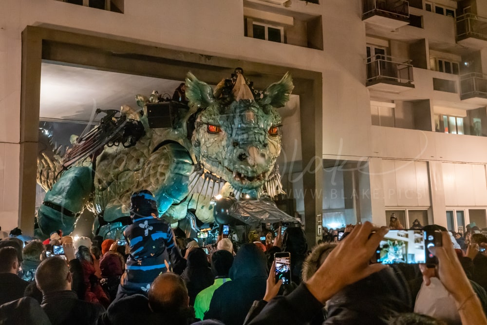 Le Dragon de Calais at night surrounded by spectators filming on their phones, Calais, France