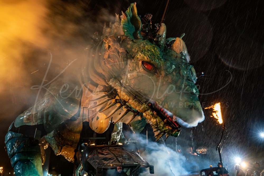 Le Dragon de Calais at night in the rain, lit by flames, Calais, France