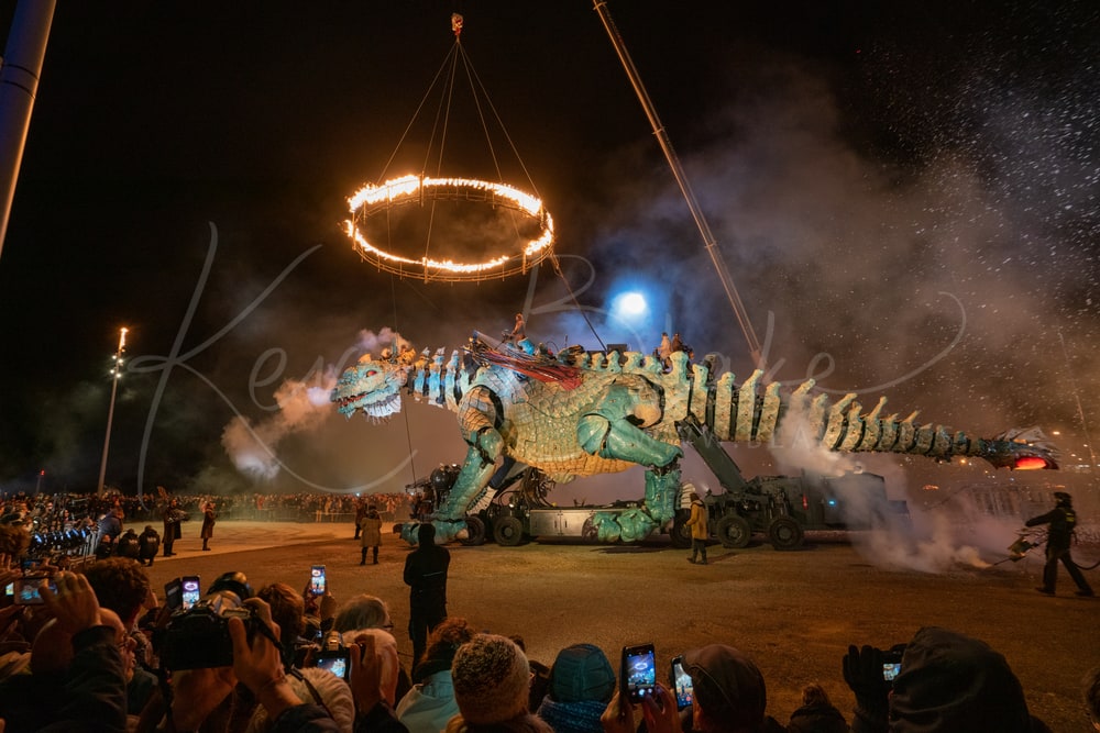 Le Dragon de Calais beneath a ring of fire at night, watched by the crowd, Calais, France