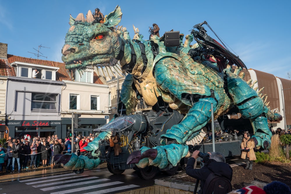 Le Dragon de Calais walking down a street under a blue sky, Calais, France