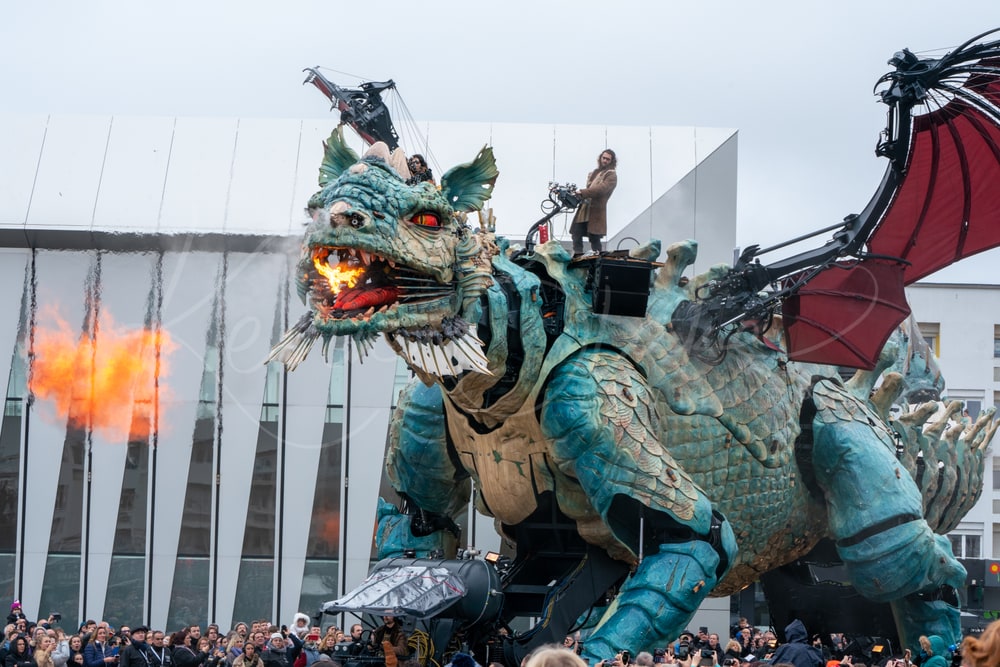 Le Dragon de Calais breathing fire as it parades past the crowd, Calais, France